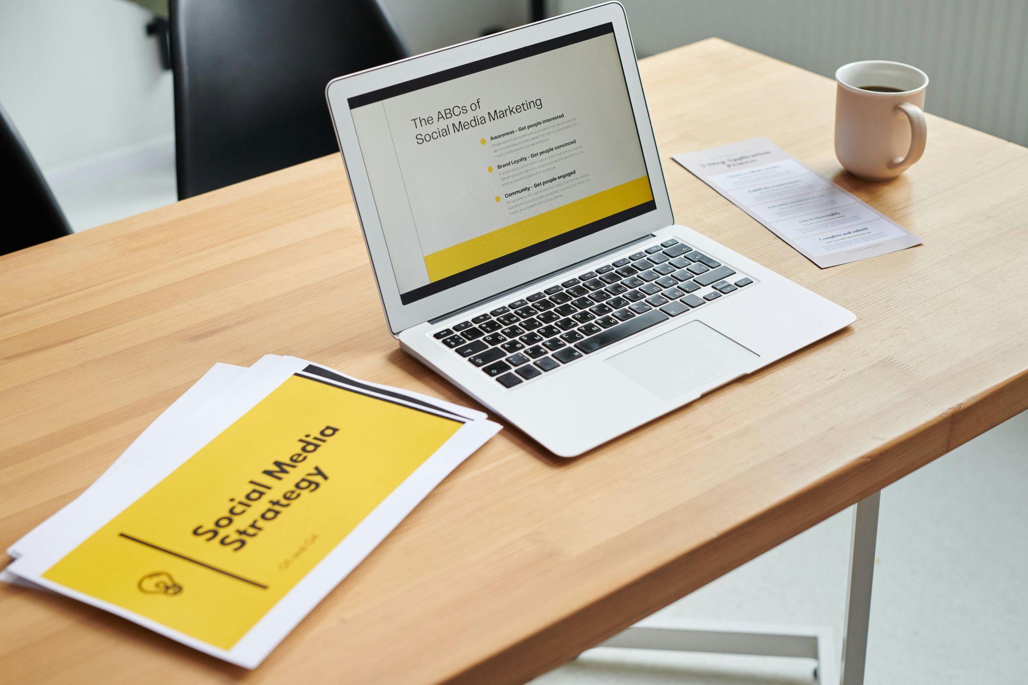Laptop displaying a social media marketing presentation on a desk.